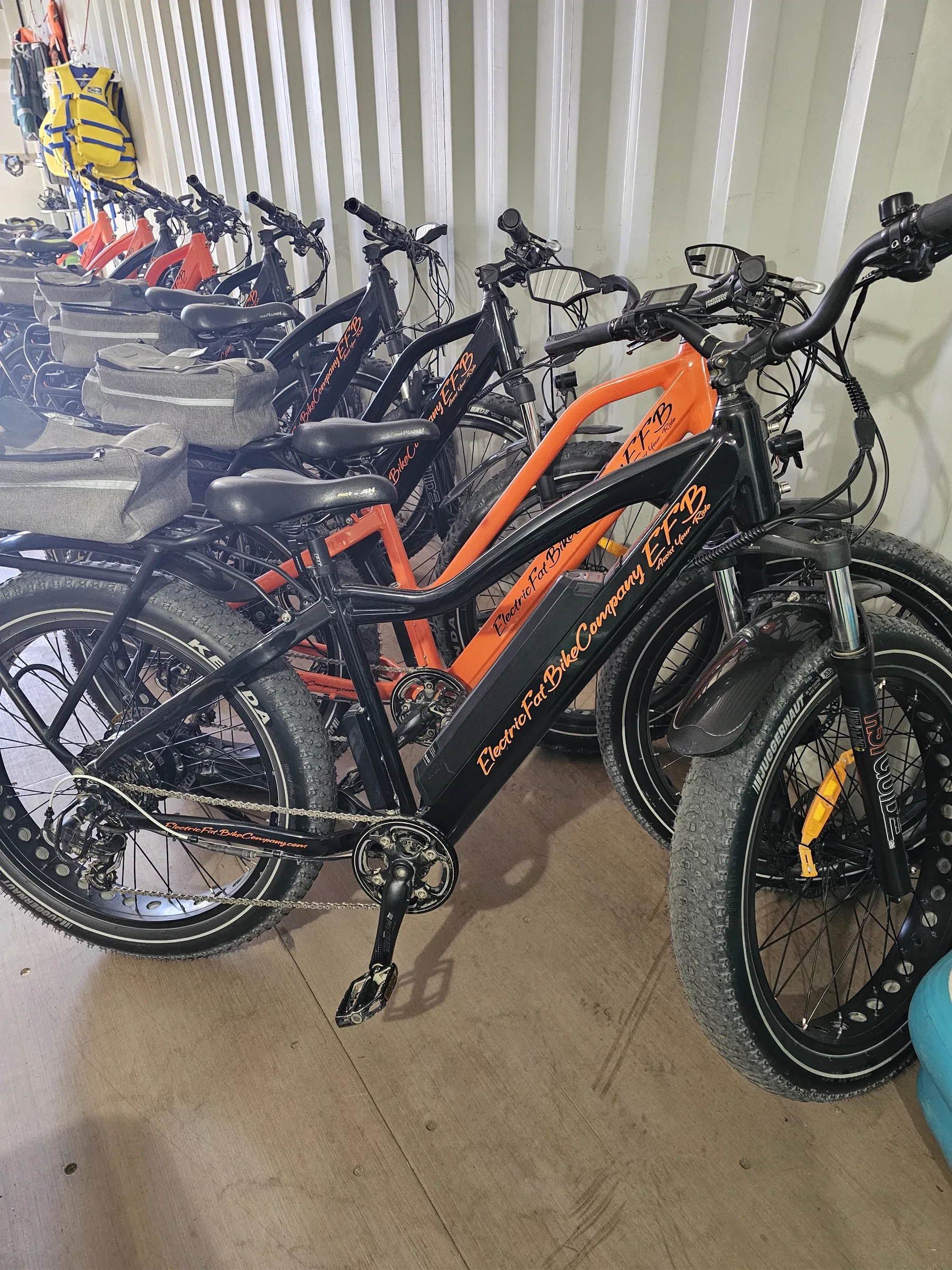 Row of rental e-bikes and life jackets stored inside the shipping container